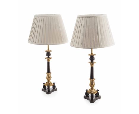 PAIR OF REGENCY PATINATED AND GILT BRONZE LAMPS  converted from candlesticks, each with a gadrooned drip tray above the acant