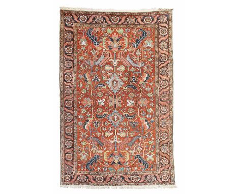 HERIZ CARPET  NORTHWEST PERSIA, EARLY 20TH CENTURY  the rust red field with allover serrated palmette and leaf pattern, withi