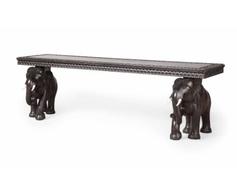 ANGLO-INDIAN CARVED ELEPHANT EBONY BENCH  LATE 19TH CENTURY  the long rectangular seat with a foliate carved border raised on