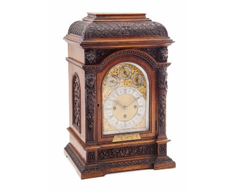 GERMAN CARVED OAK BRACKET CLOCK  19TH CENTURY  the ogee pediment carved with a central mask motif and acanthus leaf moulding,