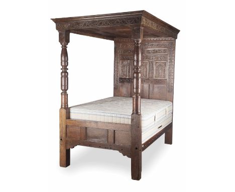 CHARLES I OAK TESTER BED  17TH CENTURY  the carved cornice and panelled tester above a panelled headboard carved with stylise