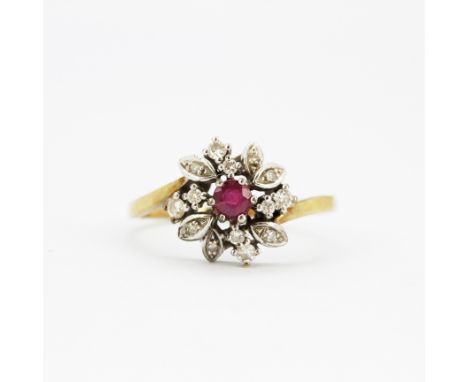 A 9ct yellow and white gold ring set with a round cut ruby and diamonds, (Q).