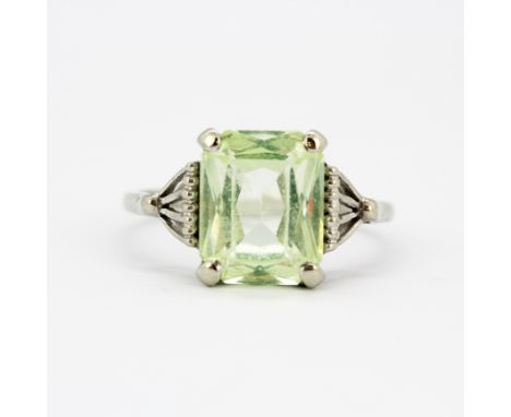 A 10ct white gold (stamped 10K) solitaire ring set with a large emerald cut green stone, stone size 1cm x 0.7cm, (M).