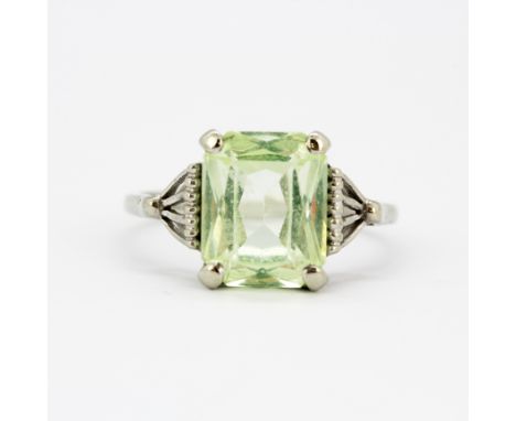 A 10ct white gold (stamped 10K) solitaire ring set with a large emerald cut green stone, stone size 1cm x 0.7cm, (M).