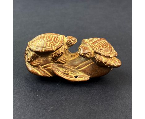 A Japanese signed fruitwood netsuke of two turtles, L. 6cm.