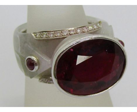 Unusual 18k white gold cocktail ring set with a large garnet to centre, flanked by two cabochon rubies and further diamonds t