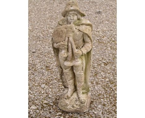 A weathered cast composition stone garden ornament of a Scottish Highlander wearing a brimmed hat and playing the bagpipes 66