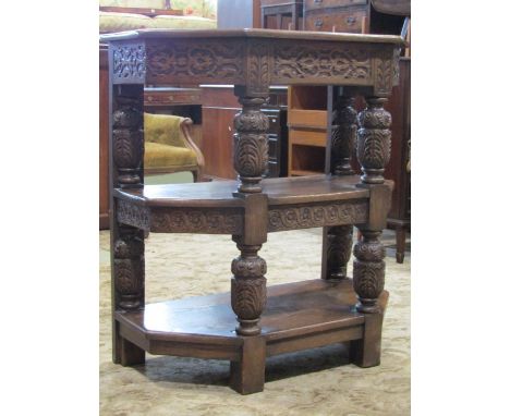 An old English style oak three tier buffet with canted corners and with plaster shaped supports overall carved detail - in an