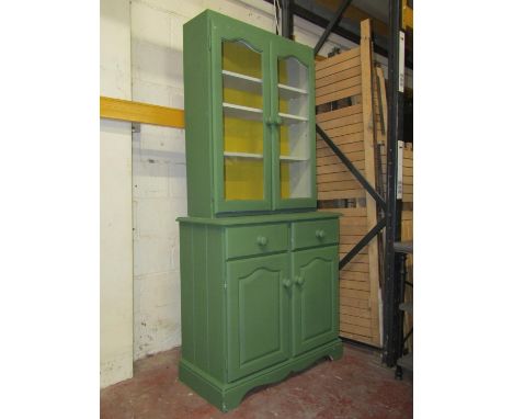 A small painted pine dresser, enclosed by two shaped doors and two frieze drawer, the upper section with two glazed doors, 90