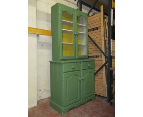 A small painted pine dresser, enclosed by two shaped doors and two frieze drawer, the upper section with two glazed doors, 90