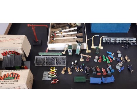 Collection of cast metal railway modelling miniatures including platform figures, seating, lamp posts, luggage carts, bicycle