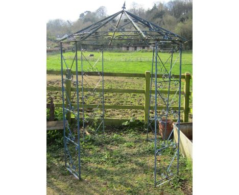 A vintage ironwork gazebo, with four main uprights, supporting an octagonal pointed canopy with simple open scrollwork detail