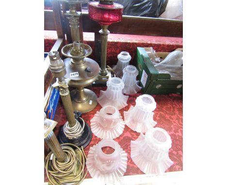 Two brass column oil lamps, a squat brass oil lamp, two electric brass column table lamps, five matching light pink crimped g