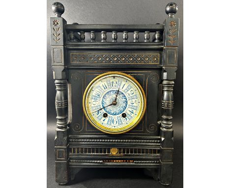 A Victorian mantle clock in the aesthetic style, the ebonised case with geometric detail and gilt highlights, enclosing a blu