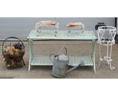 A light green painted light metal two tier rectangular garden table with repeating decorative pierced flower head detail, rai