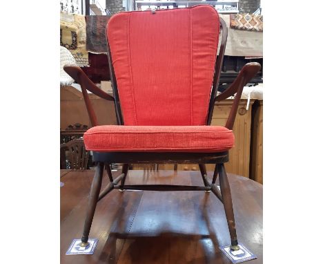 An Ercol stick back elbow chair with later upholstery 