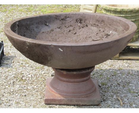 A large matt glazed terracotta planter with circular shallow bowl raised on a loose socle, 90 cm diameter x 48 cm high (af) 