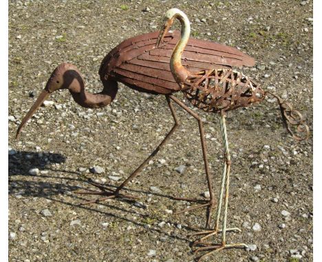 A weathered light steel garden ornament in the form of a crane 56 cm high together with one other (2) 