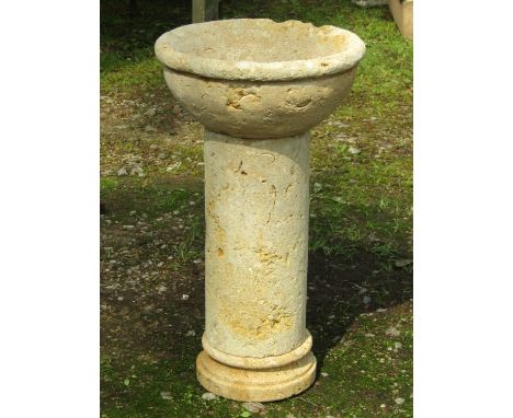 A three sectional stone planter with shallow circular bowl raised on a cylindrical hollow pedestal and platform base, 40 cm d