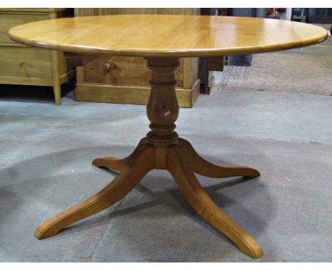 A contemporary cherry wood breakfast table with circular top raised on a turned vase shaped pillar and swept quadruped, 122cm