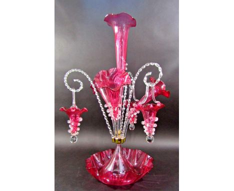 A Victorian cranberry and clear glass epergne with a central trumpet vase surrounded by a further three smaller trumpet vases