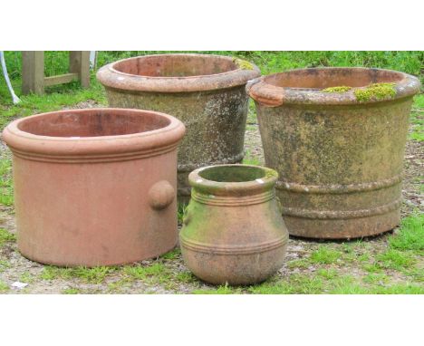 A pair of weathered terracotta planters of circular tapered form with moulded rims, ribbed and incised detail, 52 cm diameter