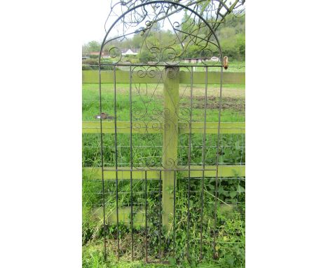 An ironwork arched pedestrian side gate with decorative open scroll detail, 85 cm (full width) x 182 cm high, together with o