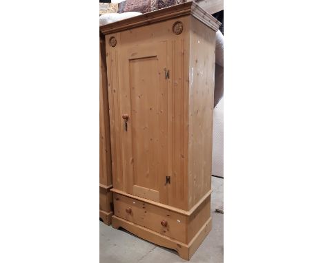 A contemporary pine wardrobe enclosed by a panelled door over a frieze drawer with tudor rose detail, 96cm wide 