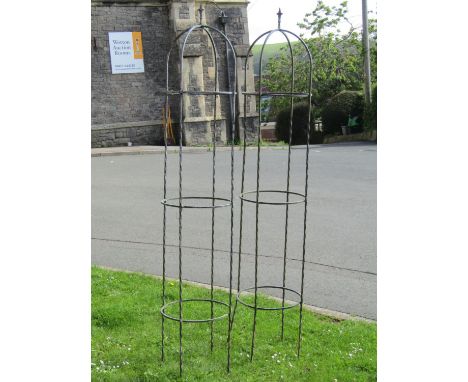 A pair of weathered galvanised steel garden obelisks with twisted rod and ring construction forming domed tops with arrow hea