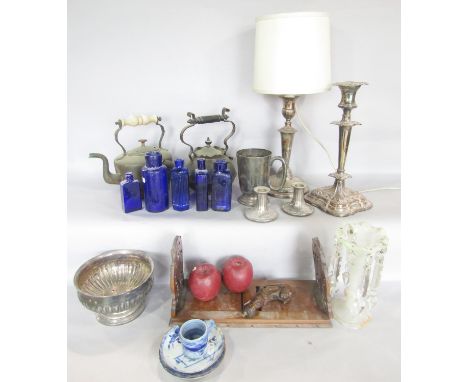 A miscellaneous collection of items including copper kettles,, silver plated candlestick and lamp,, blue bottles, a carved wo
