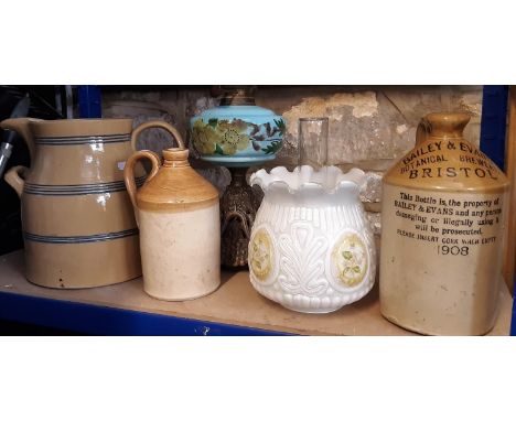 A large 19th century glazed dairy jug with loop handle and blue banded detail, 2 gallon capacity approx, an oil lamp with blu