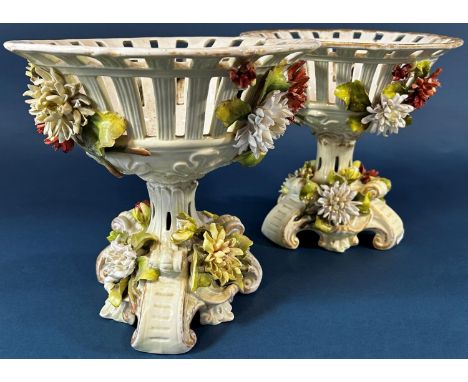 A pair of 19th century continental porcelain jardinières in the form of pierced baskets, the stem and tripod supports heavily