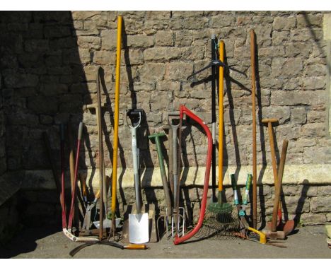 A collection of long handled gardening tools, spades, forks, rakes, bow saw etc 