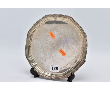 A SILVER SALVER, of a plain polished design and a textured wavy rim, raised on three scroll feet, hallmarked Sheffield 1923 '