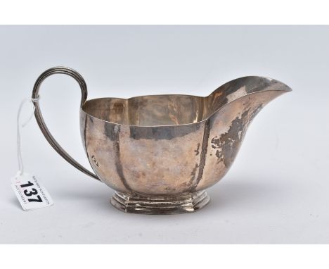 A GEORGE V SILVER GRAVY BOAT, of a plain polished wavy edge design, tapered handle, on a raised hexagonal base, base stamped 