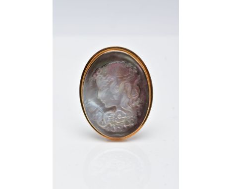 A YELLOW METAL CAMEO BROOCH, the carved abalone shell brooch of oval form depicts a lady in profile, within a collet mount an