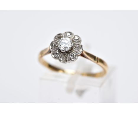 A YELLOW METAL DIAMOND CLUSTER RING, designed as a raised flower cluster set with a central round brilliant cut diamond withi