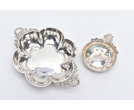 A SILVER BON BON DISH AND A WHITE METAL ASHTRAY, the bonbon dish of a flower shape, with two wreath and ribbon detailed handl