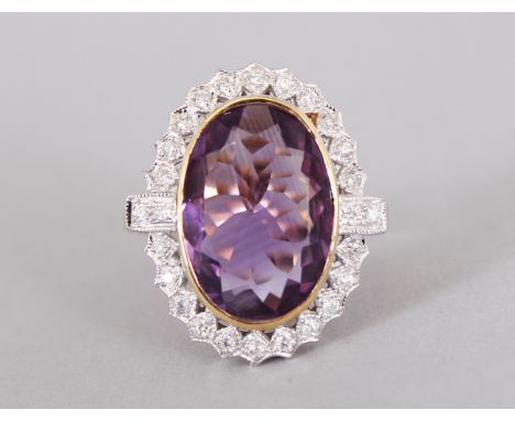 A 9CT GOLD LARGE AMETHYST AND DIAMOND OVAL RING.