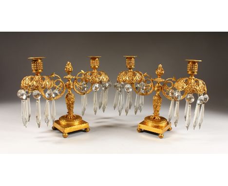 A GOOD PAIR OF REGENCY TWO-LIGHT CANDELABRA, with scrolling branches, prism drops, on square bases. 9ins high.