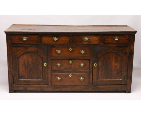 AN 18TH CENTURY OAK DRESSER BASE, with three plank top, the front with four drawers over three central drawers, flanked by pa