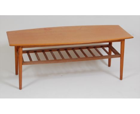 A 1960s Danish teak coffee table, having bowed sides, ladder rack undertier, and raised on plain turned slightly tapering sup