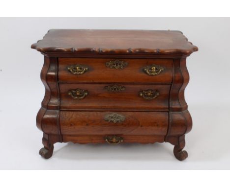 19th century Dutch apprentice-piece miniature bombe commode of shaped outline, having three graduated drawers to the undulati