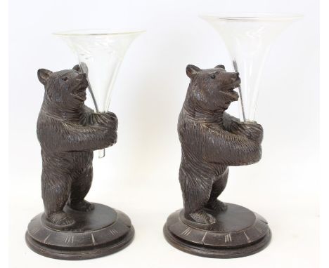 Pair carved Black Forest bears on circular bases, each holding a glass trumpet vase, circular bases marked - Biel and Bienne,