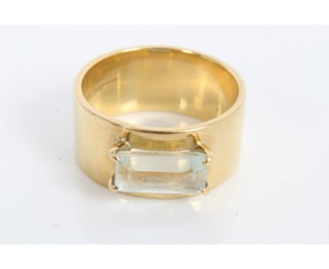 Gold (18ct) wide band with an emerald cut aquamarine in four-claw setting.  Ring size L-M CONDITION REPORT Band width 9mm.  T