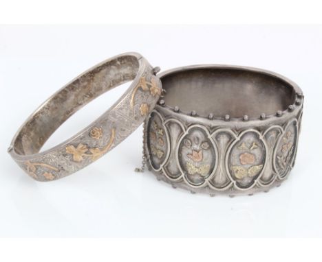 Victorian white metal hinged bangle with two-colour gold floral decoration, together with one other similar bangle (2) CONDIT