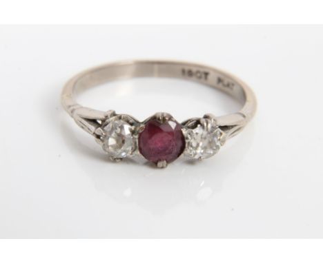 White gold (18ct) ruby and diamond three stone ring with a round mixed cut ruby, flanked by an old cut diamond to each side. 