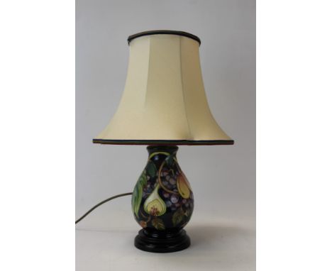 Moorcroft pottery table lamp decorated in the Queens Choice pattern on blue ground, with shade