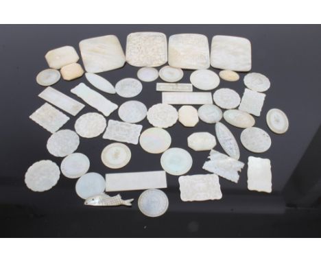 Collection of thirty-six late 19th century Chinese mother of pearl gaming counters of various forms, four large carved panels