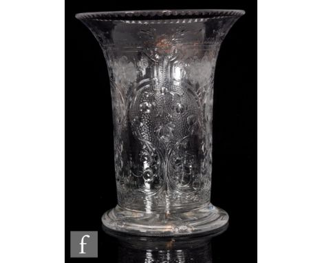 An early 20th Century Webb Corbett clear crystal vase of footed cylindrical form with a flared rim, heavily decorated with a 